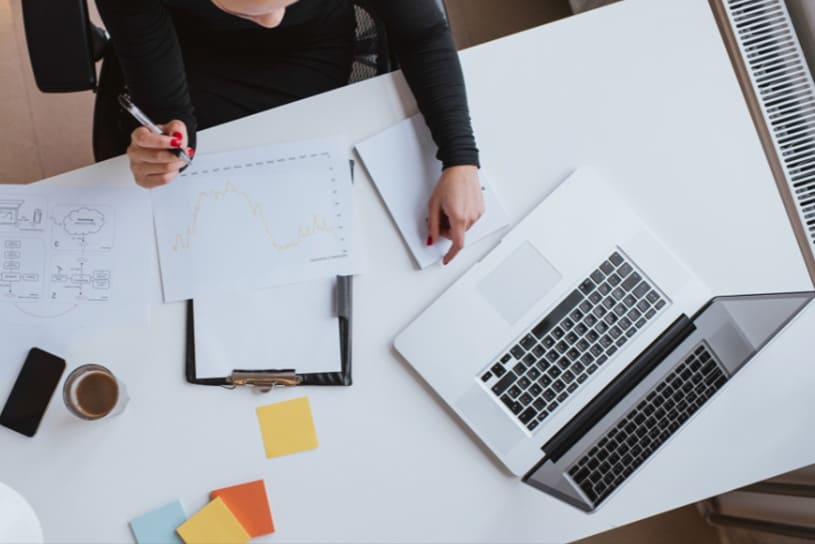 Persona revisando documentación técnica y datos en un entorno de trabajo digital, simbolizando el rol estratégico y transversal del CISO en la gestión de la ciberseguridad empresarial.